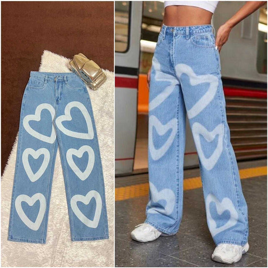 Light blue jeans with white heart patterns on a textured surface and worn by a person in an urban setting.